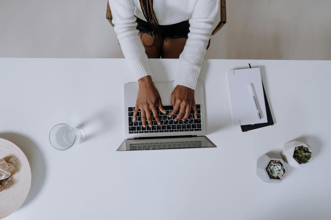 a top down photo of someone typing at their macbook